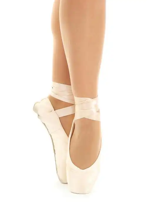 芭蕾舞女演员的脚在普安特上白色背景特写