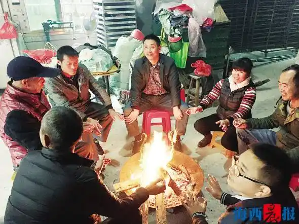 军营村的村民围炉烤火,聊天.记者 陈雅玲 摄