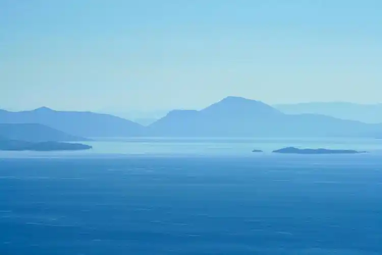 蓝色自然朦胧蓝天下的群山和大海自然山水背景图片