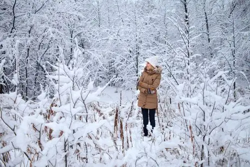 在冬天穿暖和的衣服的女孩是白雪皑皑的丛林照片-正版商用图片0o0t2q