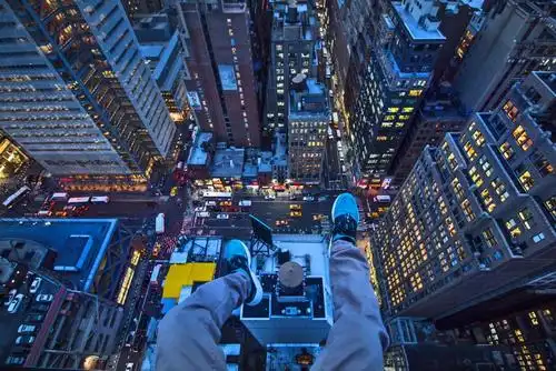 建筑,在建筑物的顶端不顾危险地将双脚悬空,俯拍了许多令人晕眩的照片