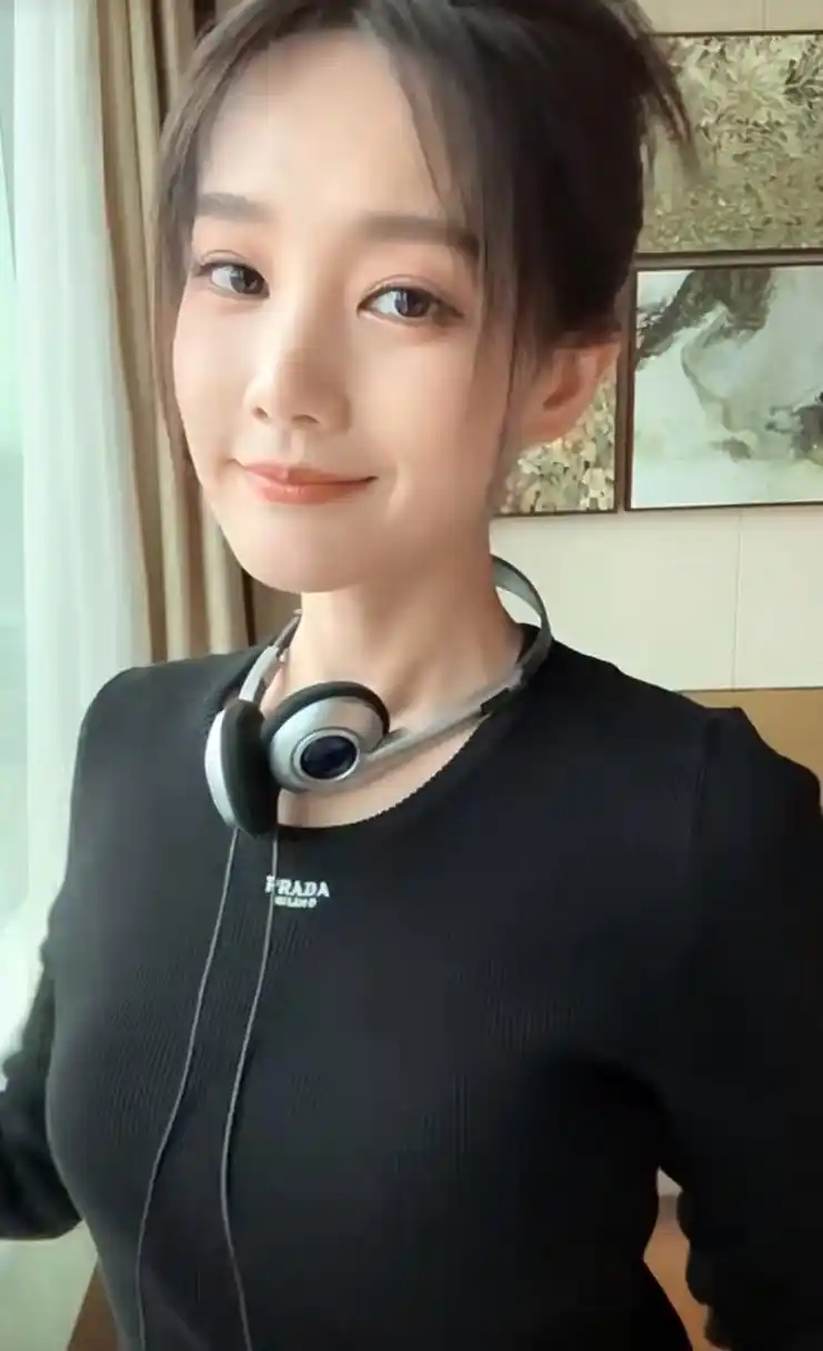 李一桐在窗户边美美自拍,手里拿着新的高跟鞋,黑色上衣和黑色鞋子十分