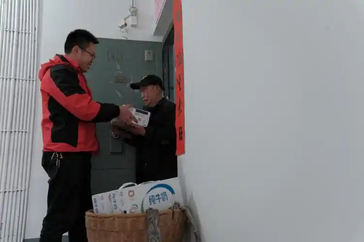 黔江"伊利棒棒军"将牛奶送到老人手中.伊利集团供图 华龙网发