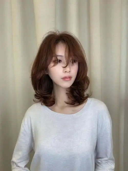 因为这是一款染发极有潮流感的锁骨卷发型,中长发式的锁骨卷发设计成