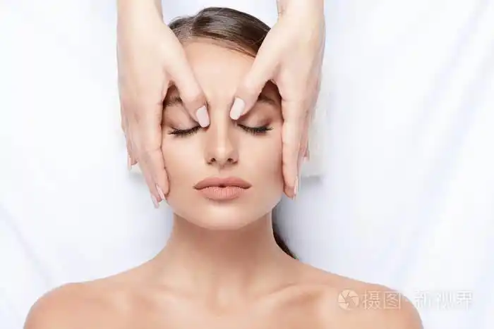 拥有完美肌肤的年轻女子面部按摩, 手上的脸, 皮肤护理, 水疗程序和