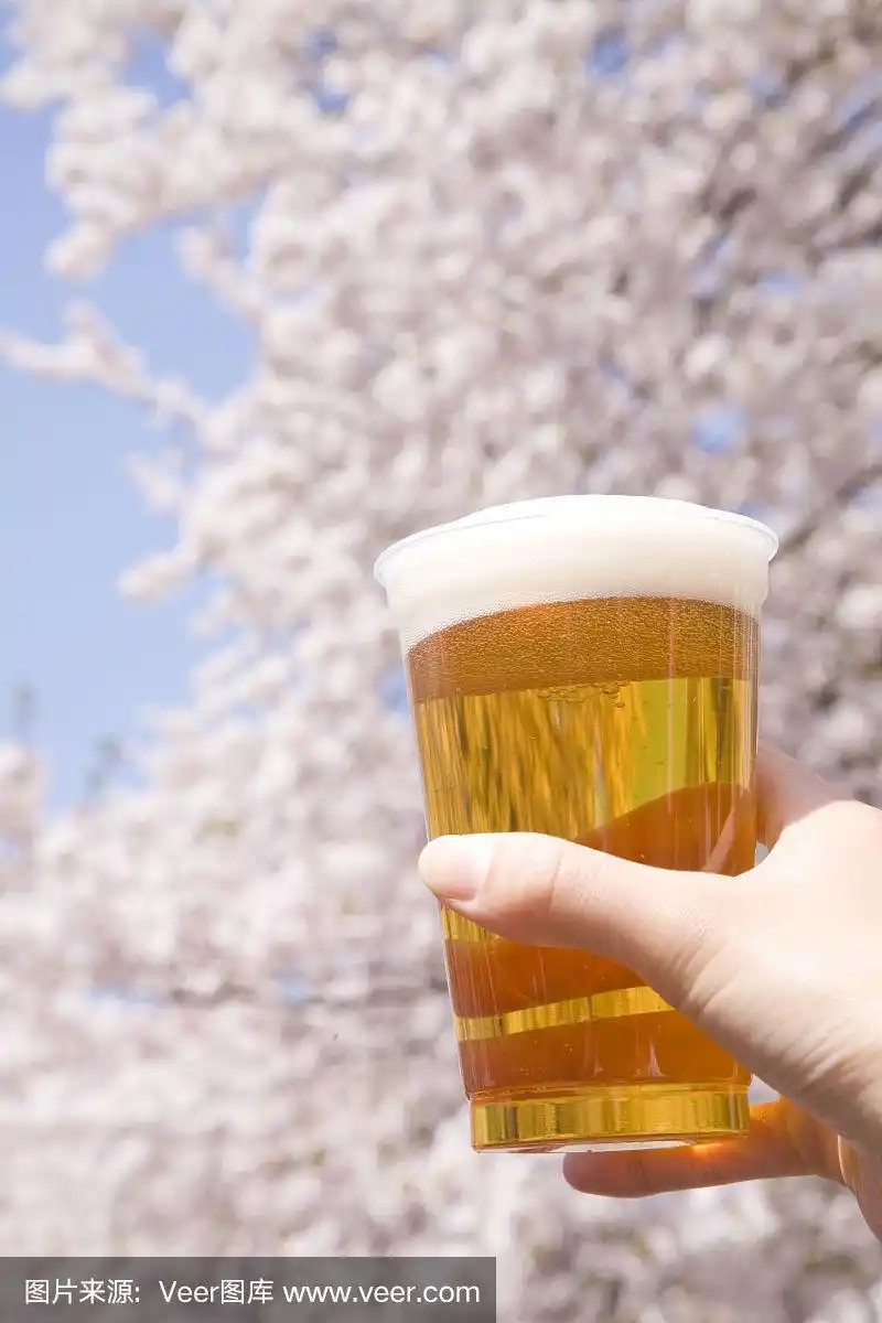 樱桃树下的女人手里拿着啤酒