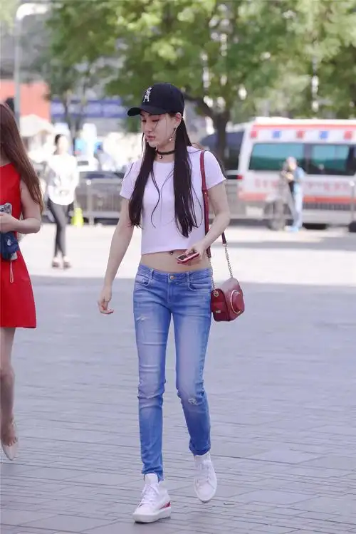 低腰紧身牛仔裤搭配出露脐装搭配一双内增高的运动鞋
