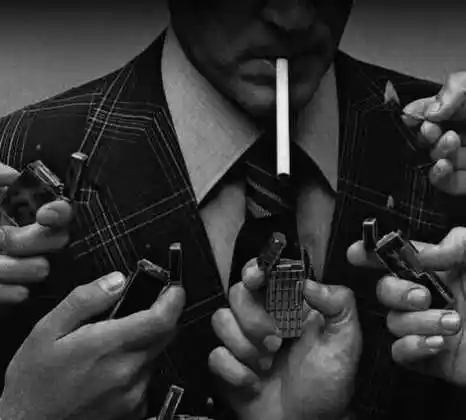 一个男老外叼着一根烟下面有很多个打火机给他点烟的图片求原图