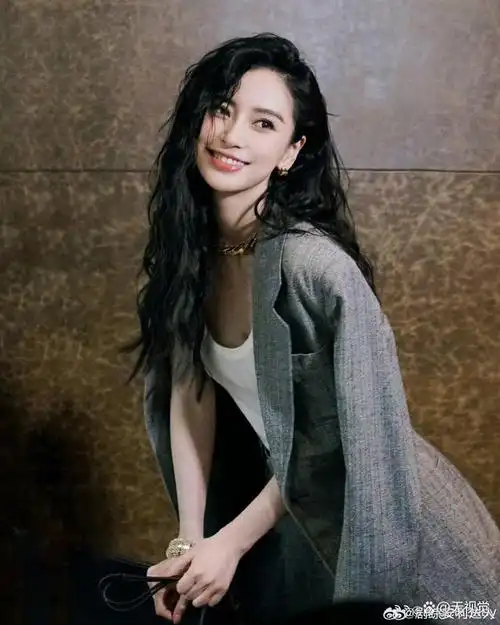 照片中的angelababy换上了时尚的羊毛卷发,脸颊,眼角,眉下点了三颗痣