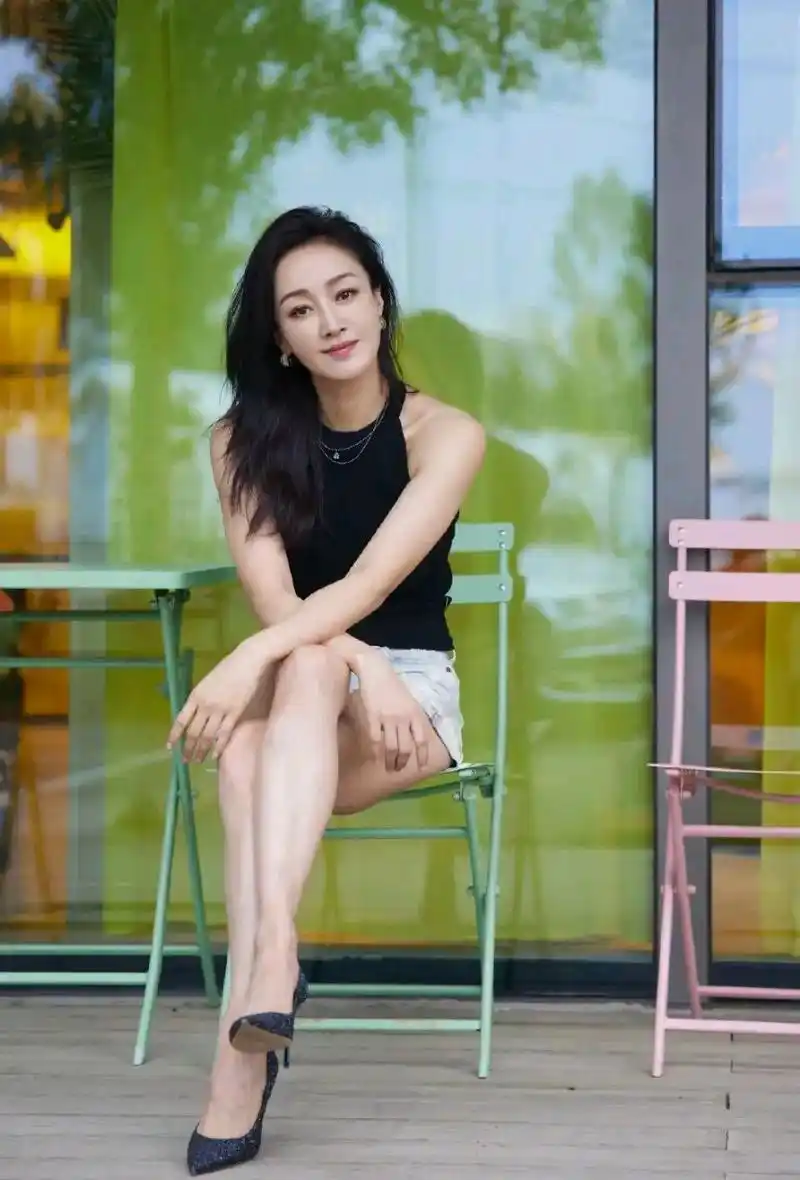 照片中,47岁的赵子琪坐在门外的绿色椅子上.