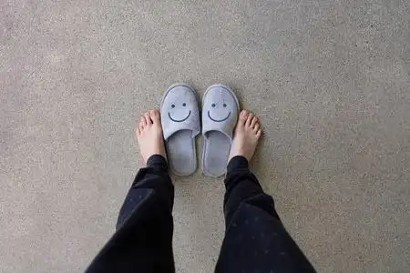 灰色拖鞋, 关闭女人的脚穿微笑灰色拖鞋在水泥背景穿拖鞋的女人躺在家