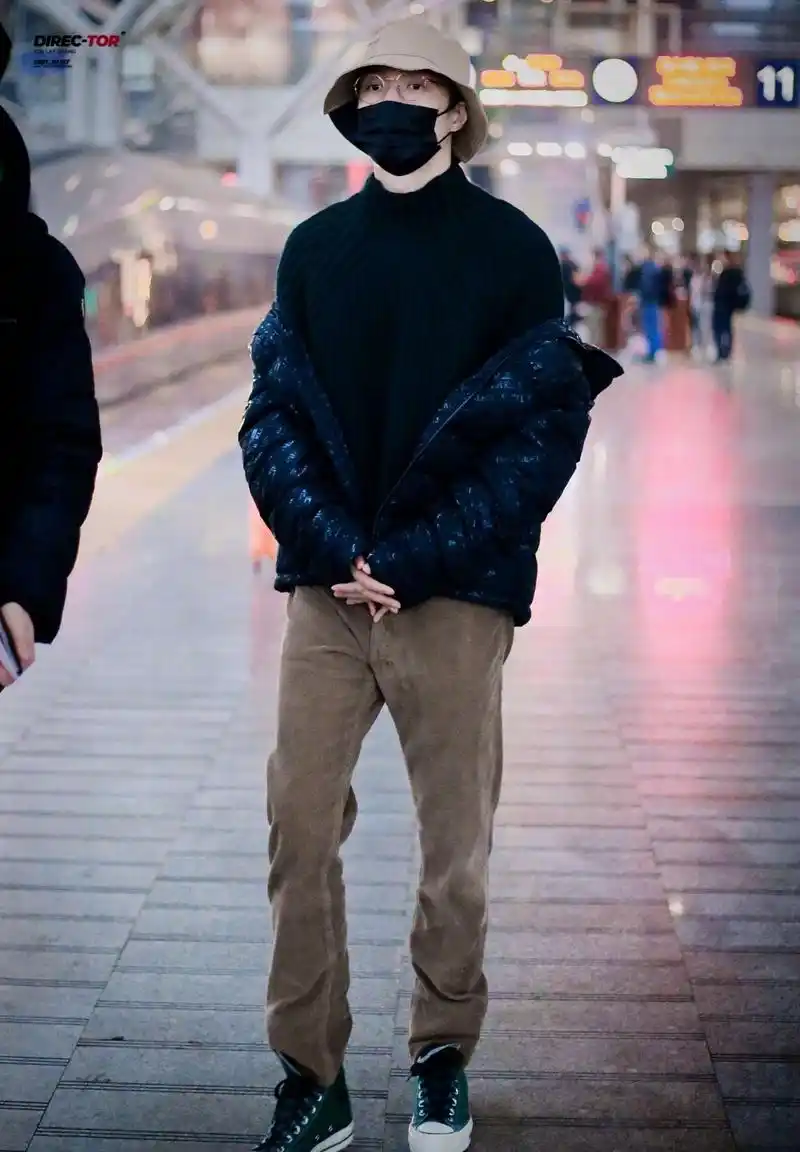 张艺兴行程饭拍图,身着深色毛衣配亮闪羽绒服,休闲舒适男友穿搭