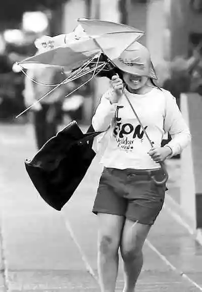 9月19日,在台湾高雄市,一名行人在风雨中行走.