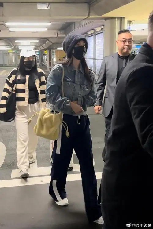 杨幂冷帽牛仔外套到达伦敦机场照