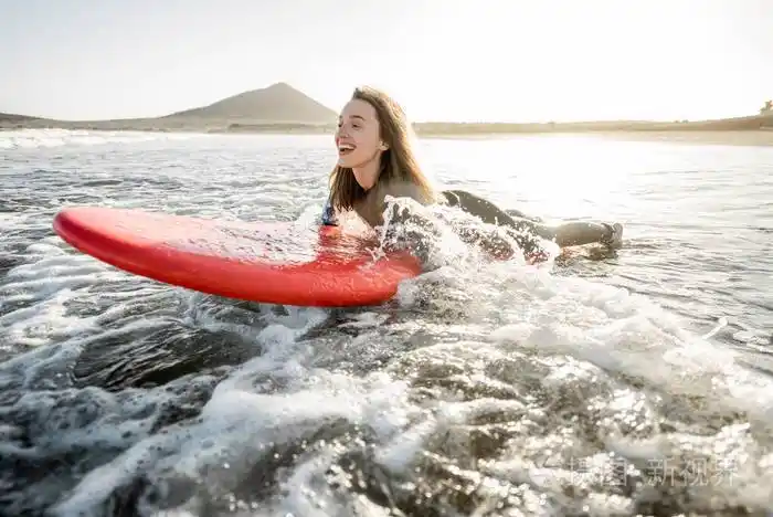 在冲浪板上游泳的女人