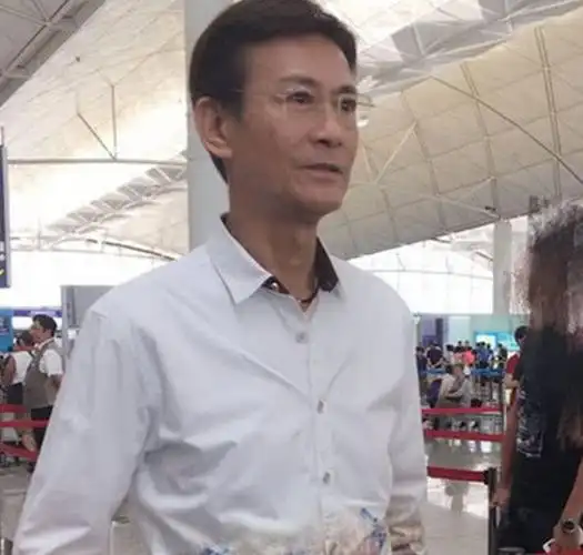 身穿一件白色衬衫搭配黑色裤子,1米82身高的郑少秋身材保持依旧很好