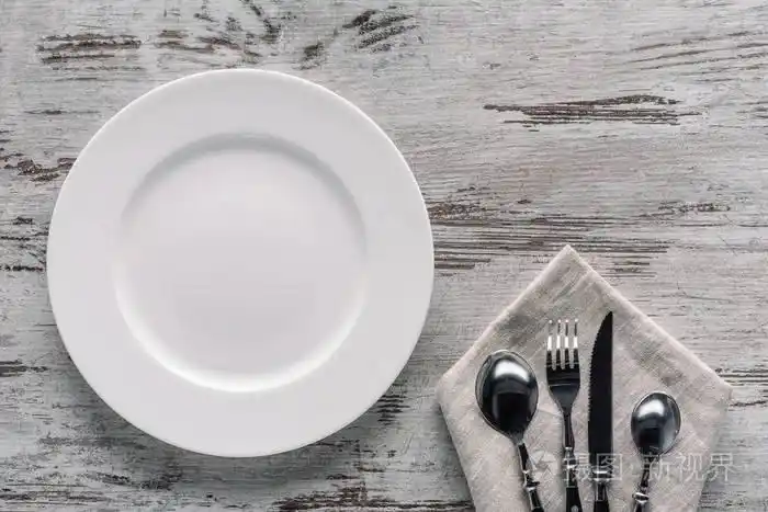 木质餐巾上的白盘子和餐具