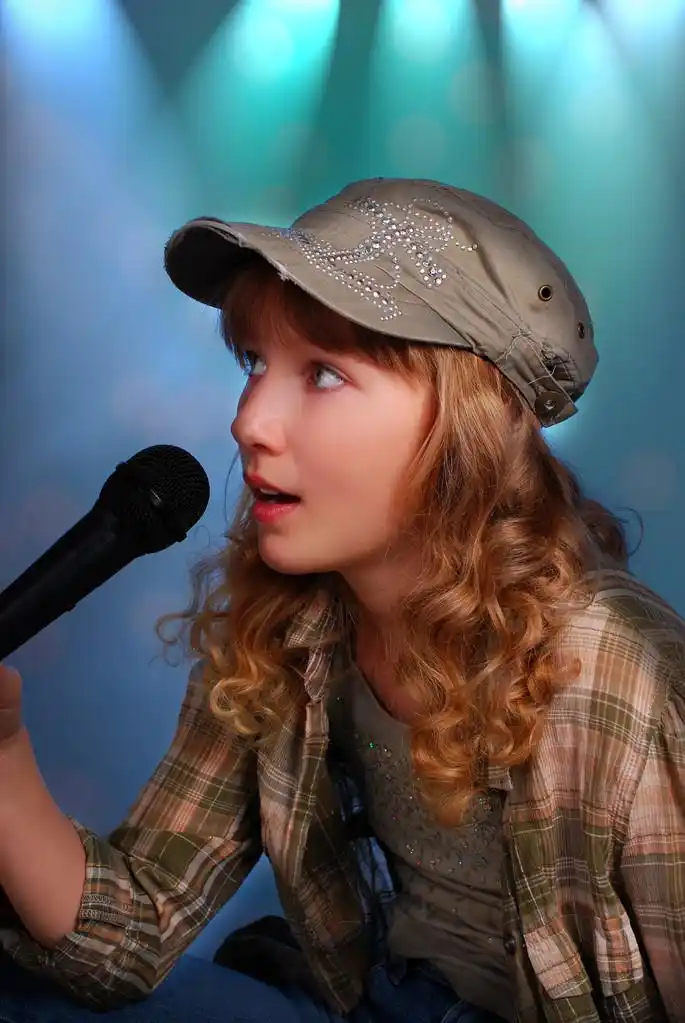 年轻女孩在舞台上用麦克风唱歌