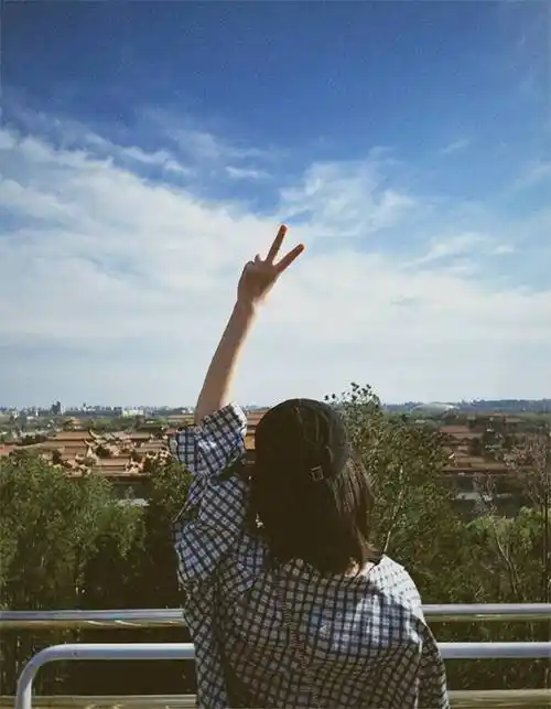 蓝天红墙好天气,映衬得倪妮更美了,举手比耶,虽然只有背影,但看起来