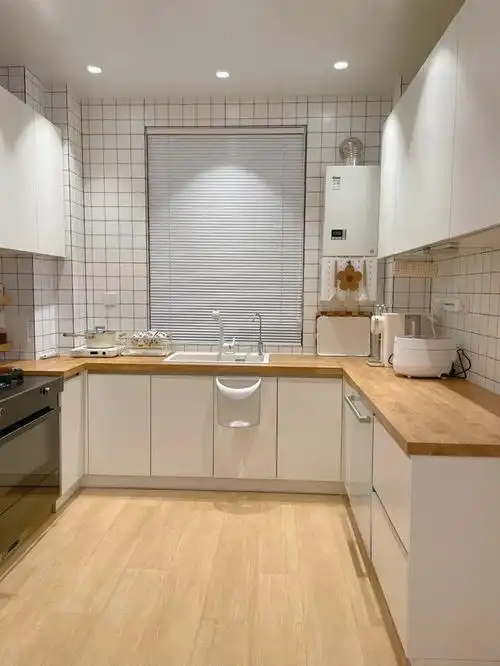 橱柜是u型布局,白色的柜体搭配木质操作台面;吊柜做了两排,把中间