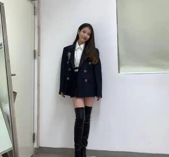 真的是超级令人着迷,脚上一双黑色过膝长靴,一头长发造型的iu,化着
