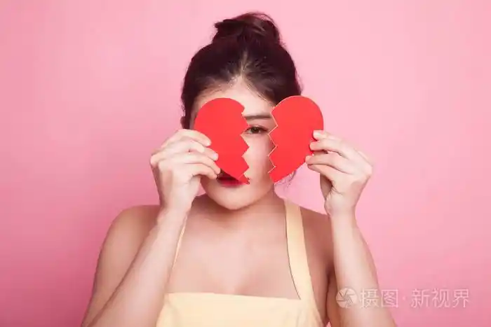 美丽的年轻亚洲女人心碎的粉红色背景