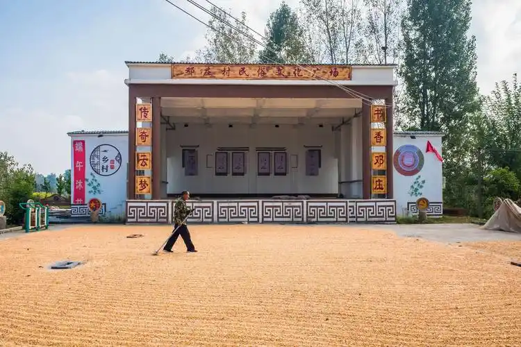 08,驻马店驿城区蚁蜂镇小邓庄村文化大舞台,村民在广场晾晒玉米.