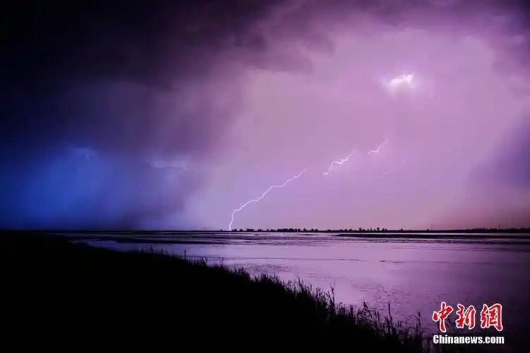抓拍到闪电照亮河面的精彩瞬间,闪电有白色,淡橘红色还有紫色,瞬间把