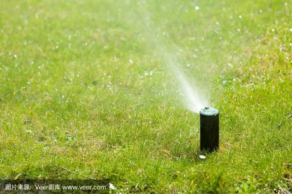 园艺.草坪洒水车在草地上喷水.