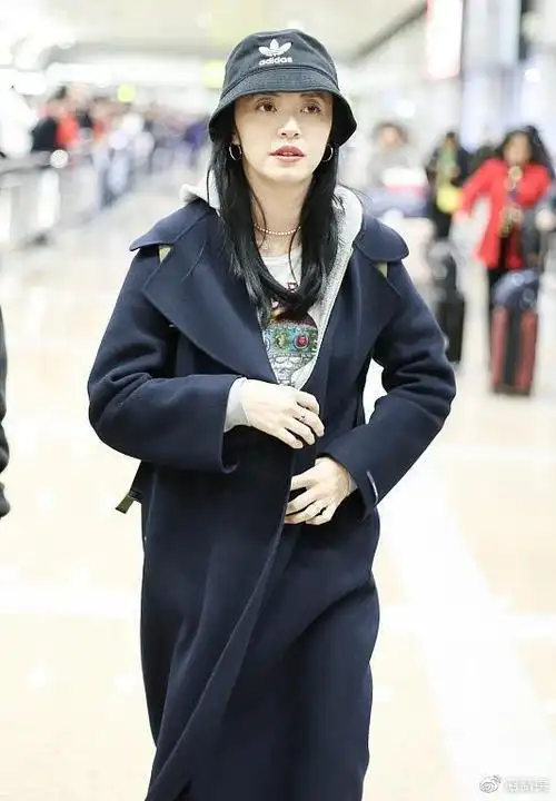 40岁姚晨穿黑长风衣现身机场皮肤白皙状态好低头浅笑显娇羞