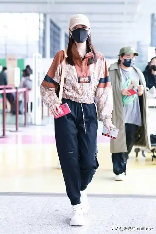 街拍:钟楚曦棕红色花纹套头衫休闲时尚,黑色工装裤显修长身材_机场