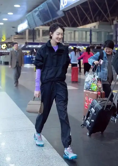 周冬雨黑色工装现身机场 紫色内搭明亮个性引人关注