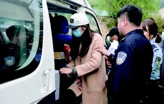 民警将醉驾女司机押上警车带往看守所.