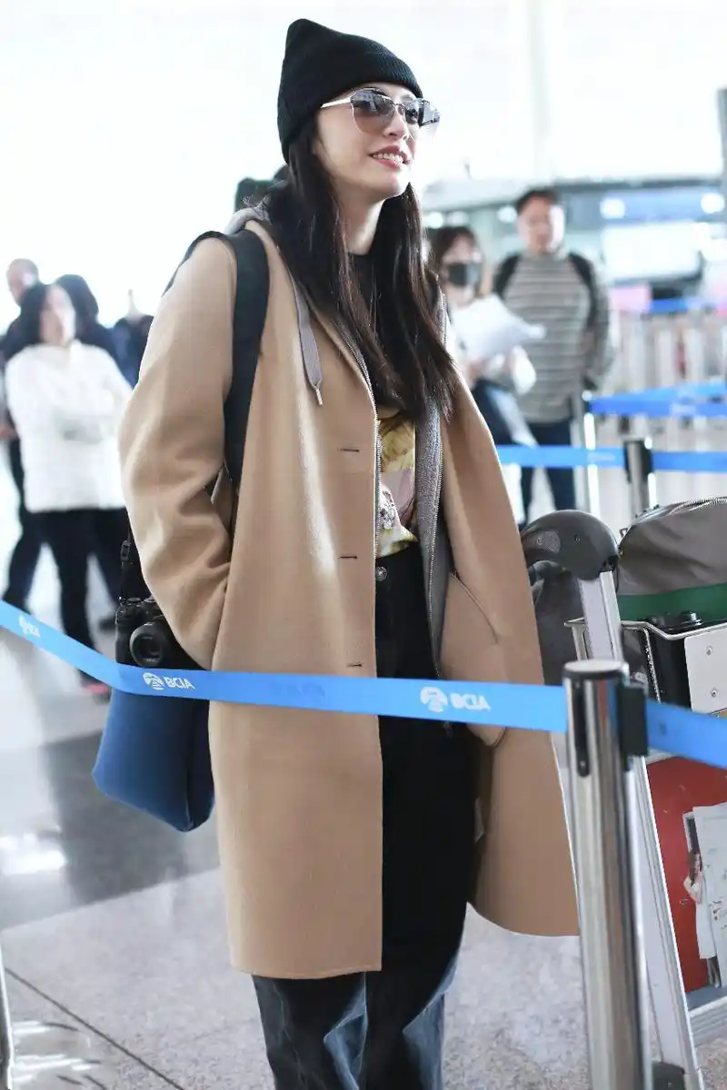 姚晨戴毛线帽和墨镜穿卡其色长款大衣现身机场,皮肤白皙笑容灿烂