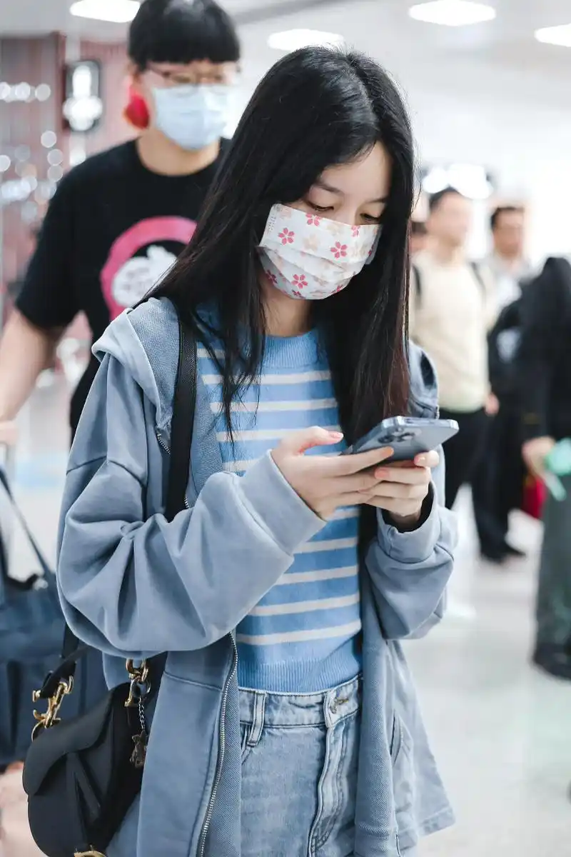 素颜可爱又亲近  周也身穿水洗做旧宽松连帽卫衣外套,内搭蓝色条纹