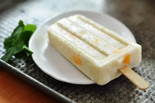 2,将剩余的芒果丁倒入搅拌机,加入细砂糖和牛奶搅拌.