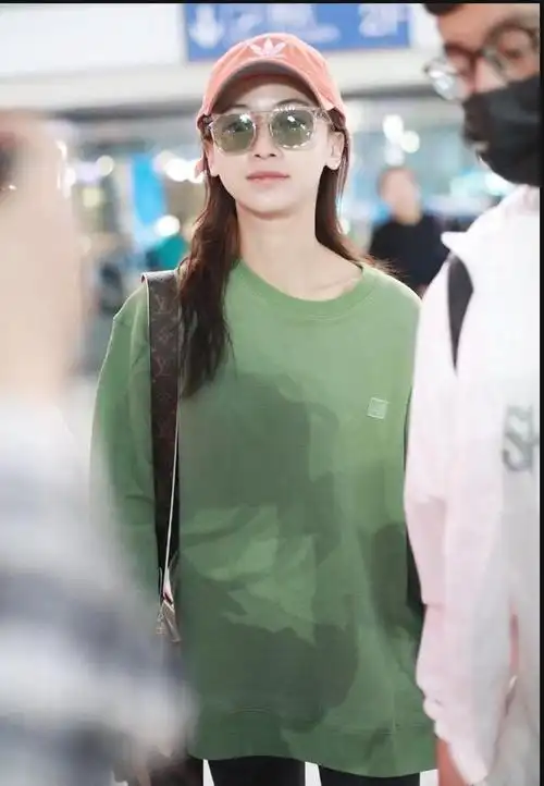 吴谨言身穿绿色卫衣搭配黑色紧身裤现身机场打扮时尚清新