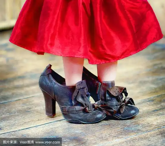 小女孩穿着她妈妈的高跟鞋