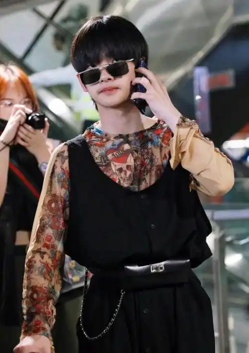 周震南在穿这款黑色连体裤时,在腰间系上一个腰包