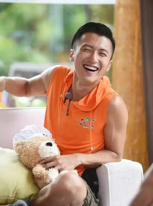 住着一个大男孩,穿着亮橘色背心的谢霆锋笑起来傻里傻气像个孩子一般