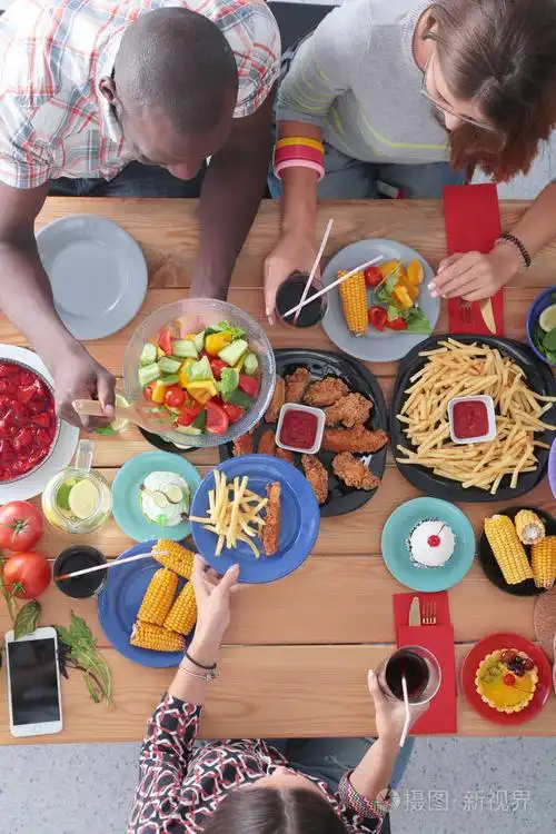 照片 顶视图的一群人在一起时坐在木桌吃饭.在桌子上的食物.