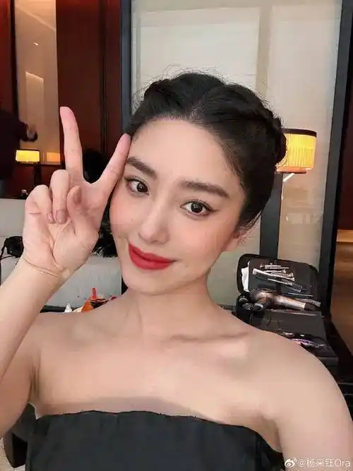 就像这张美图,杨采钰身穿红色抹胸长裙,侧身凝视的样子很妩媚,俏脸