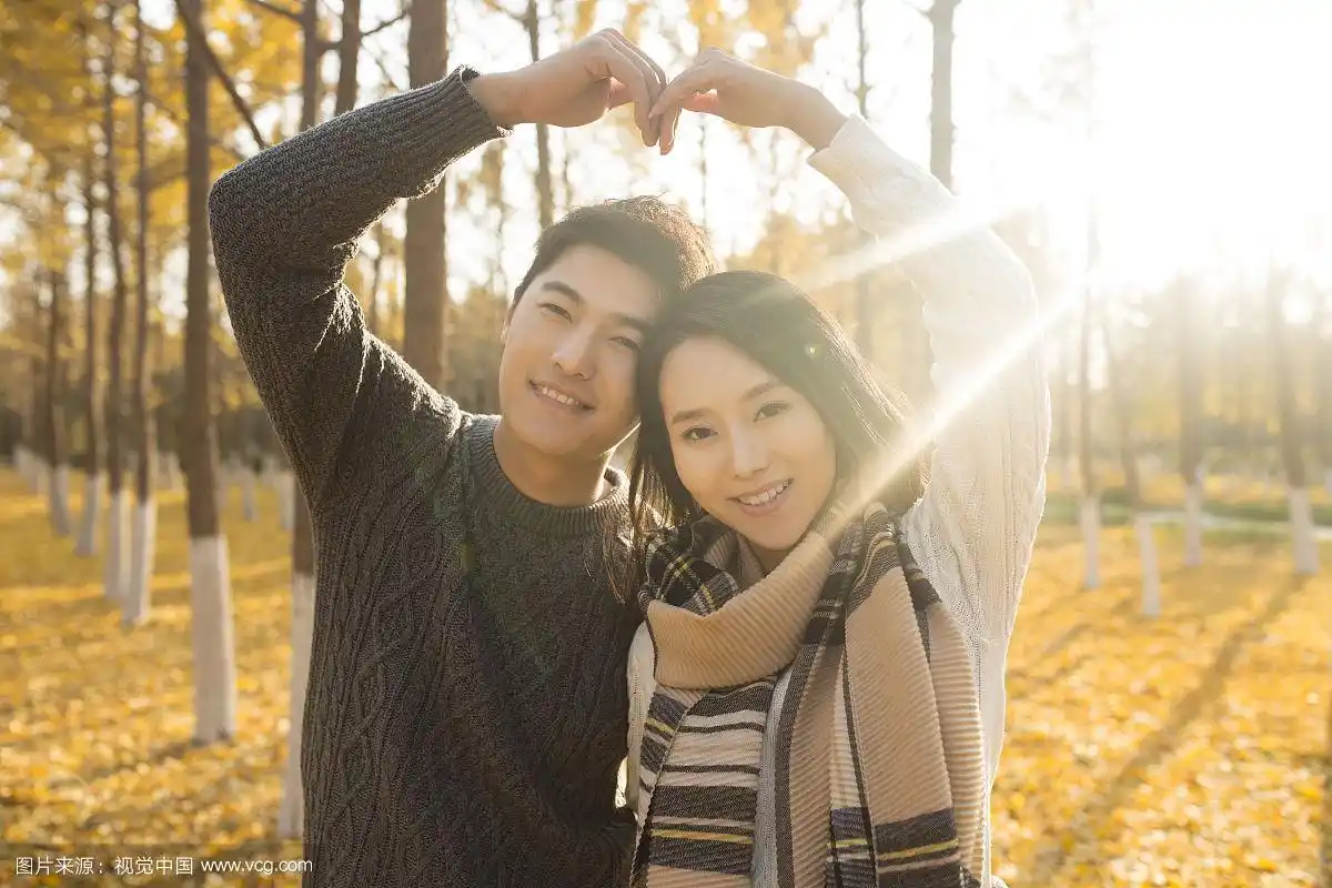 快乐的年轻情侣摆心型手势