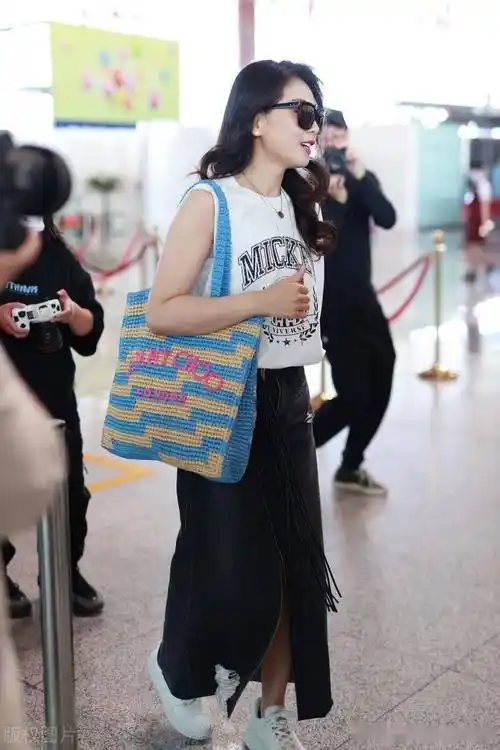 街拍:刘涛波浪长发 钩针包 半身裙 小白鞋随性休闲_北京_机场