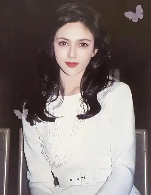 镜头中,关之琳身穿黑色毛绒外套,一头短发,趴在桌子上,精致的容颜和手