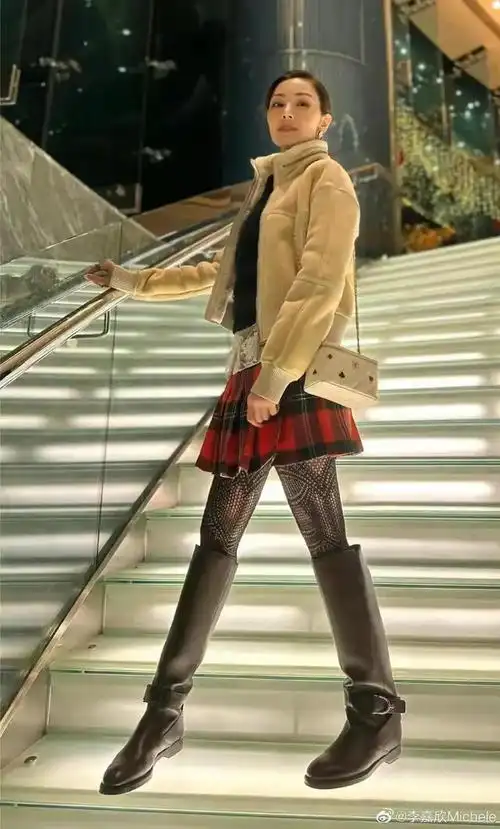 李嘉欣披着一头长发,戴着墨镜遮面,身穿白色针织外套和牛仔裤,背着一