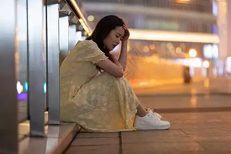 悲伤难过的女性坐在路边图片素材