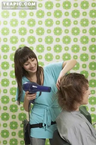 [理发店为顾客吹头的女发型师]