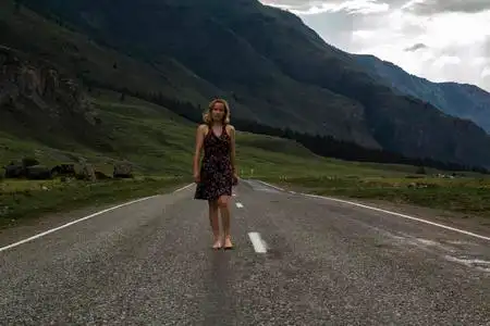 一个赤脚的女人沿着山路走.旅游,旅游和人的概念照片