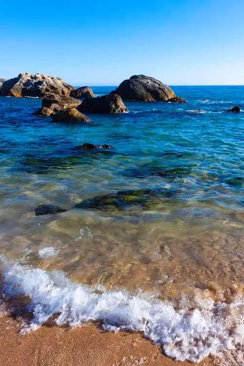 波光粼粼的大海,岩石和蓝天的地平线照片-正版商用图片261n6t-摄图新